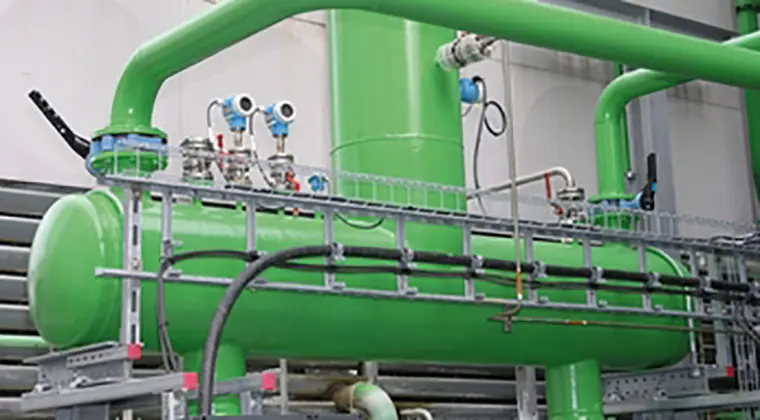 A green tank surrounded by green pipes.